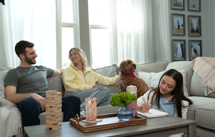 Family sitting on the couch with their dog Family sitting on the couch with their dog